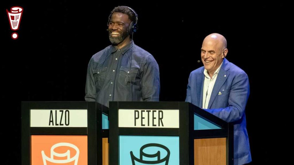With Not My Job guest Caro Claire Burke : NPR Alzo Slade and Peter Sagal on stage at the Studebaker Theater in Chicago